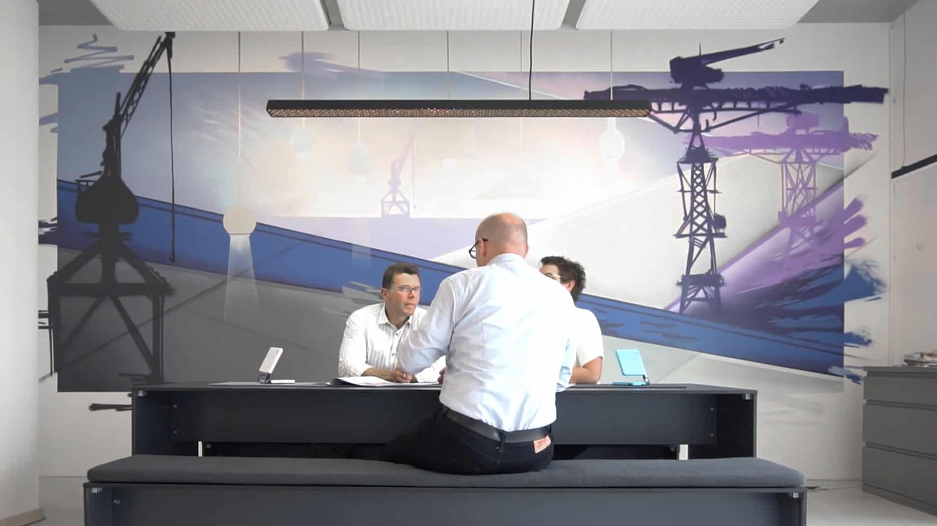 Meetingbereich mit großem Büro Graffiti, das Kräne und industrielle Strukturen zeigt.
