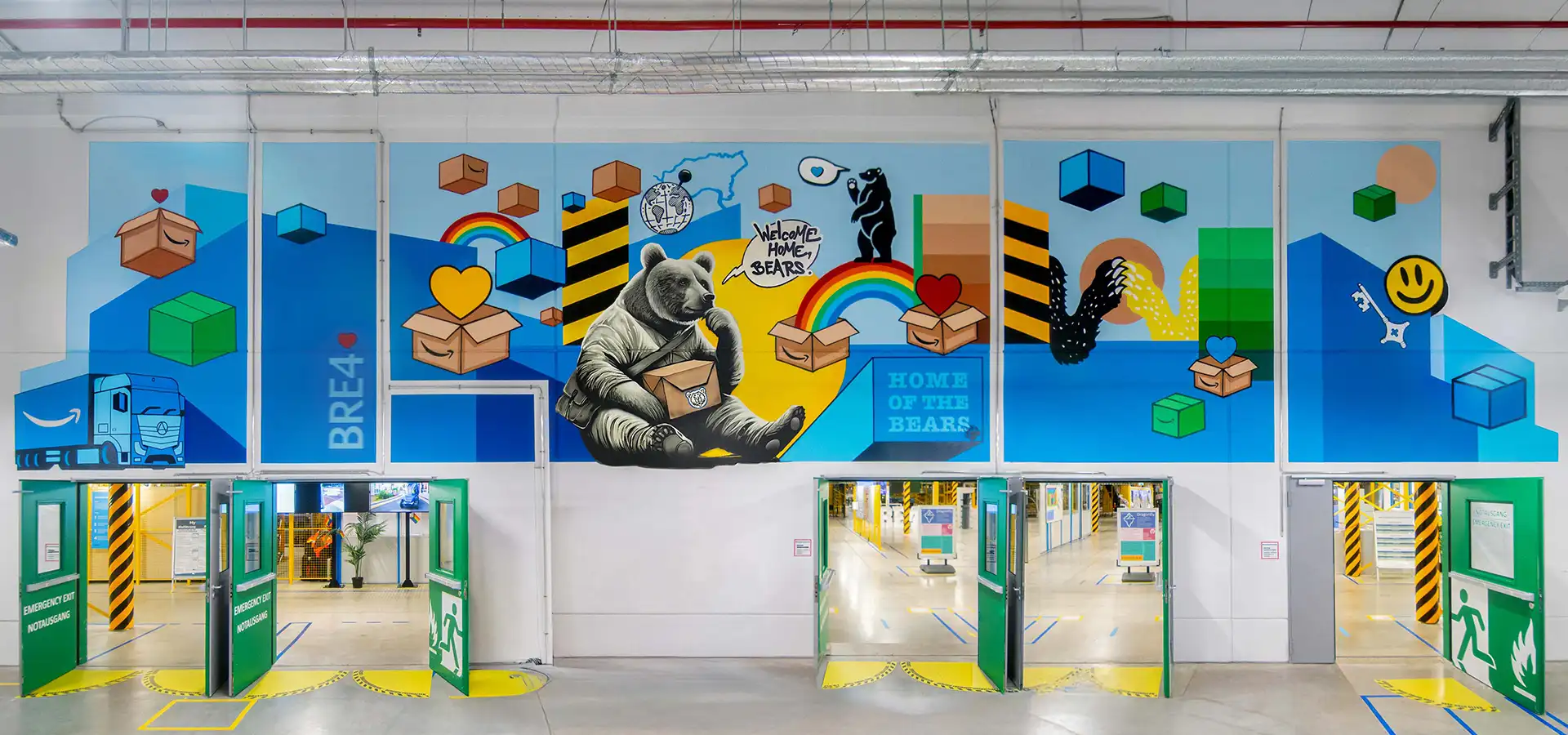 Großflächiges Graffiti im Amazon Logistikzentrum mit Bärenmotiv, Paketen und farbenfrohen Designelementen.