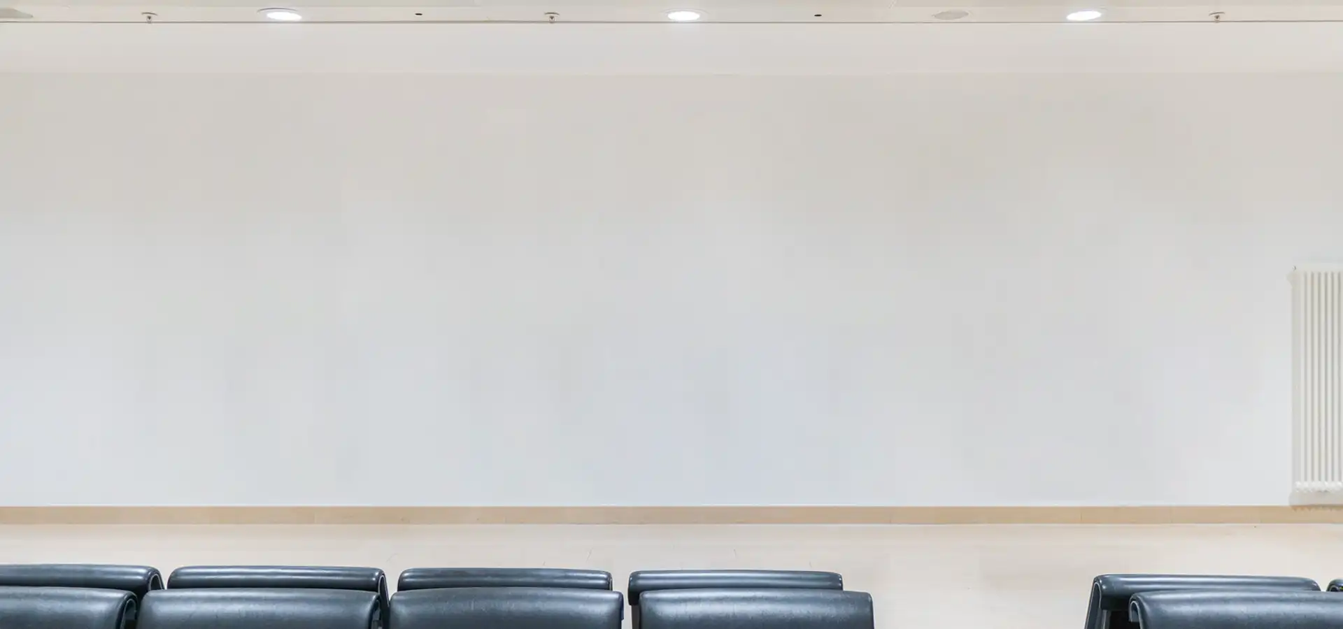 Weiße, ungestaltete Wand in einem Wartebereich vor der künstlerischen Gestaltung.